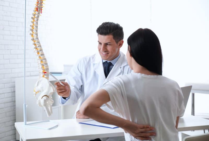 a woman and a doctor discussing low back pain
