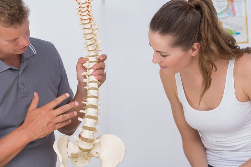 man explains herniated discs to a woman